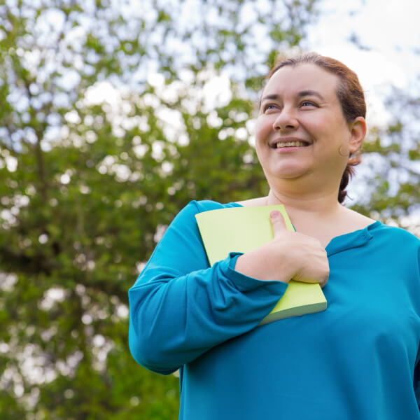 Une personne écrivant dans un journal de gratitude le matin, entourée d'une ambiance calme et chaleureuse.